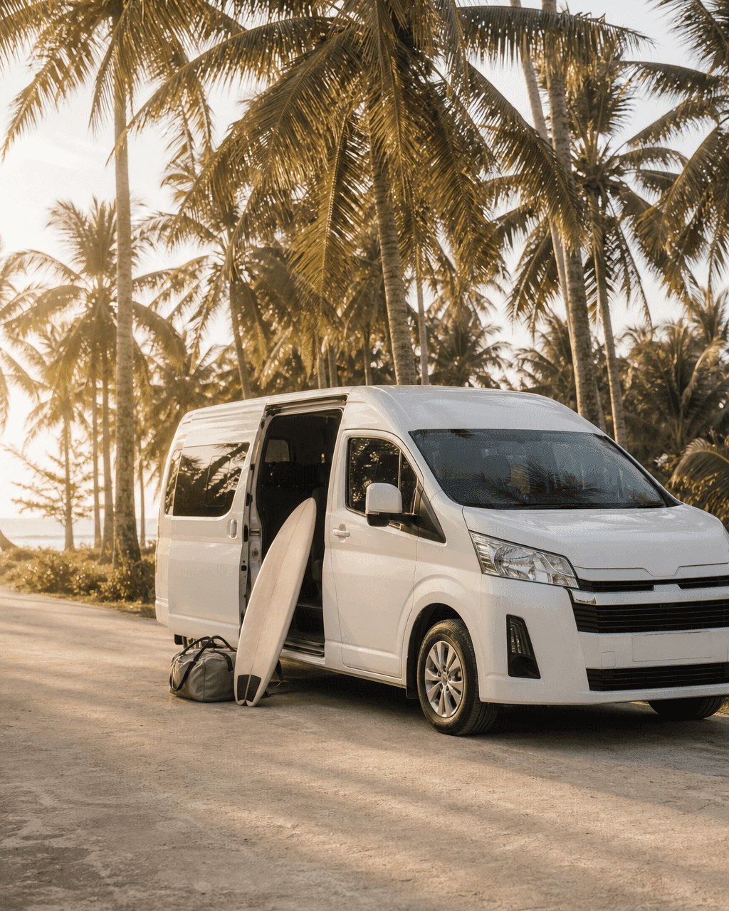Clean private van parked on a quiet coconut-lined road in Siargao, with a surfboard ready for pickup