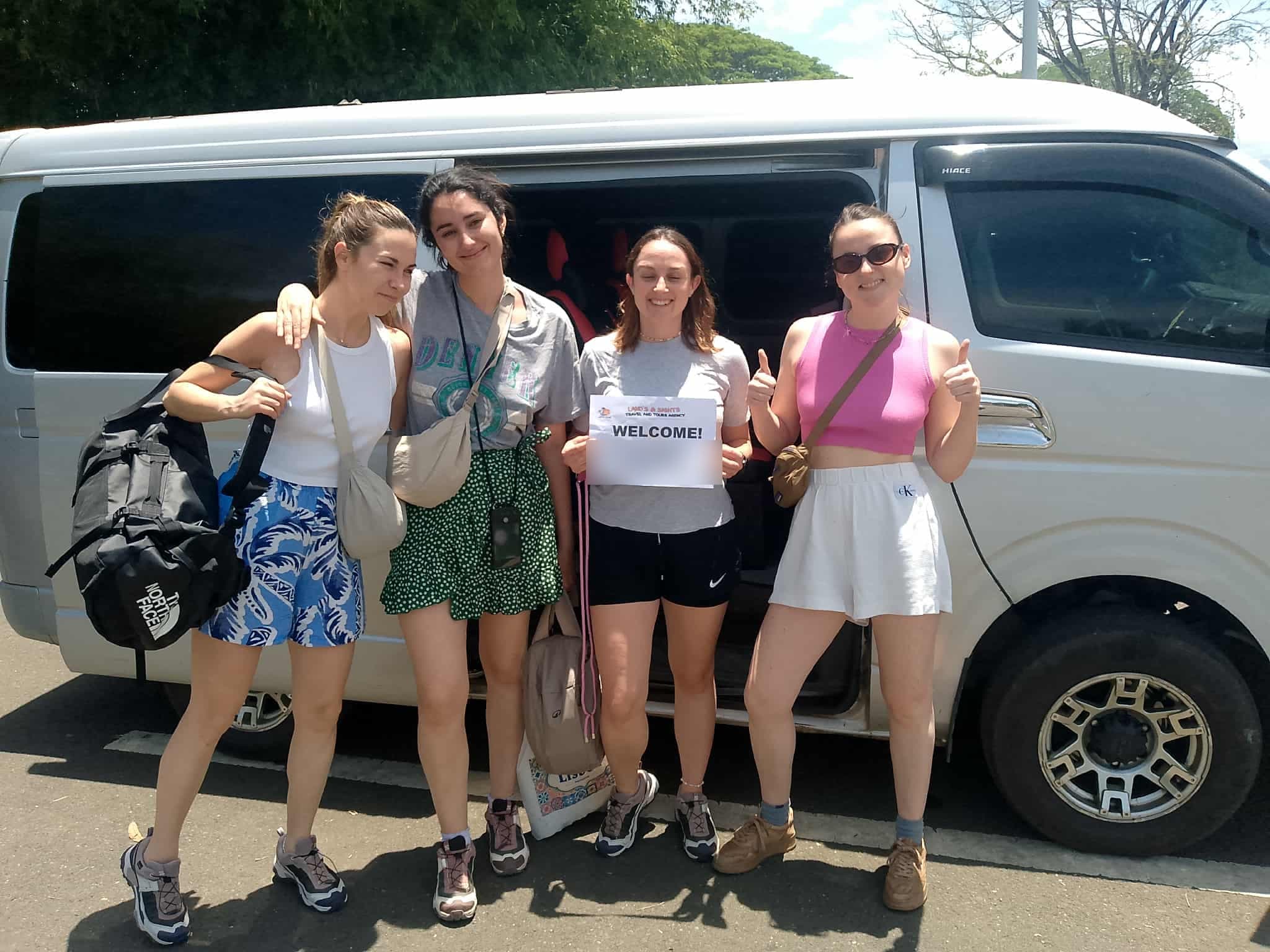 Passengers standing beside a private airport pickup van in Siargao