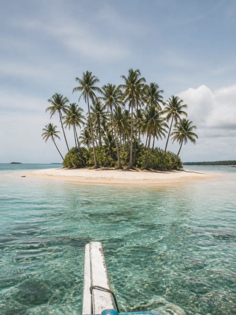 A tiny palm-topped islet like those visited on a Siargao island-hopping trip